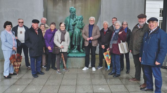 Eine Gruppe der Gögginger Geschichtskreises rund um Heinz Münzenrieder (im Bild rechts neben der Statue) begab sich auf die Spuren des berühmten Hofrats Friedrich Ritter von Hessing. Foto: Daniela Ziegler